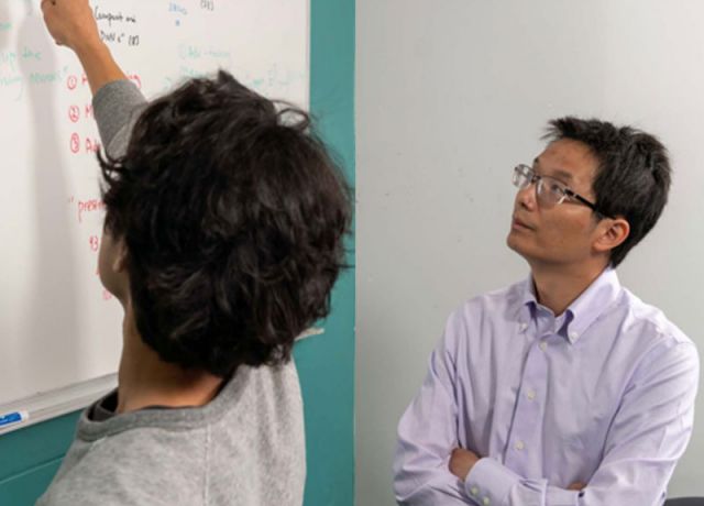 photo of student at the whiteboard while zhang observes