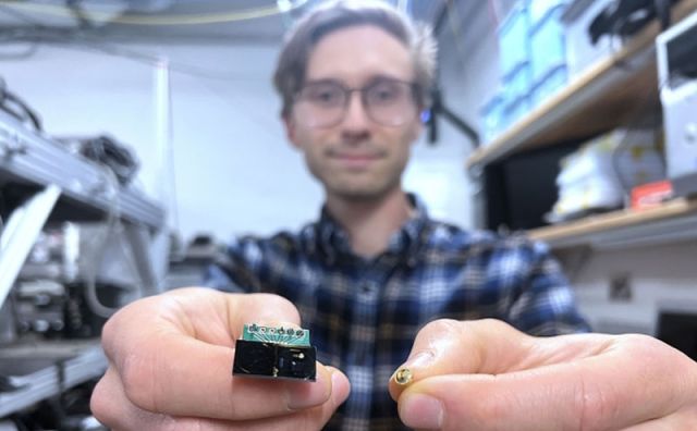 photo of Isichenko holding the ultra-high-quality ring resonator