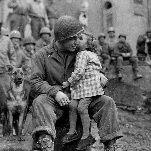 French little girl kisses American soldier after the liberation of France from German occupation, 1944