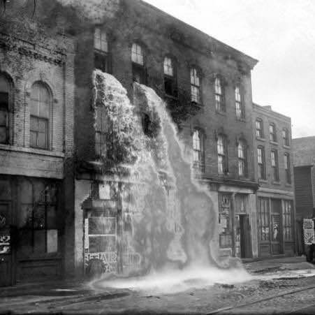 Illegal alcohol being poured out of storage building during Prohibition, Detroit, 1929