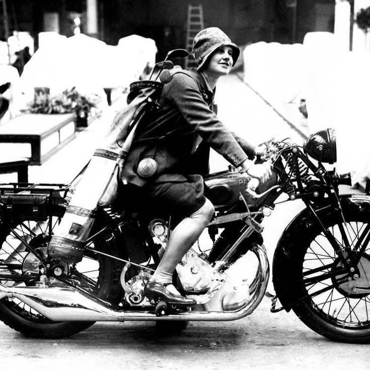Young woman riding a motorcycle with a golf bag on her back, 1928