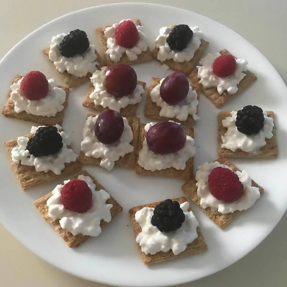 Healthy snacks: Cottage cheese and fruit on Triscuit crackers