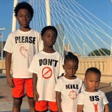 Black kids wearing four T-shirts, with the words 'Please Don't Kill Us'