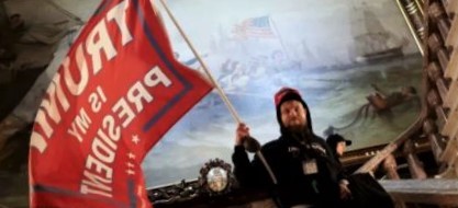 Mob member inside the US Capitol Building carrying a 'Trump is My President' flag