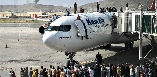 What are these people doing atop an airplane at Kabul Airport? This isn't a train!
