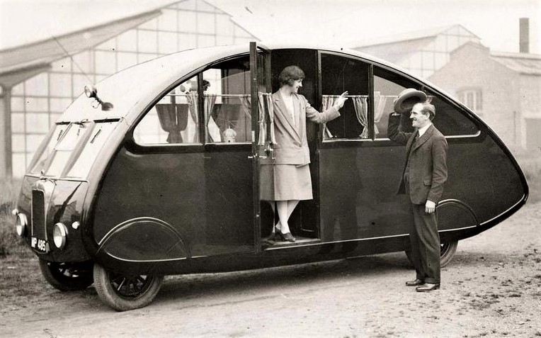 Vintage camper: A woman standing in the doorway of an RV-camper at an exhibition in London, 1927.